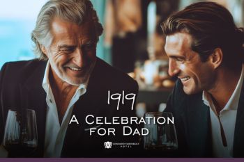 father and son smiling with wine glasses