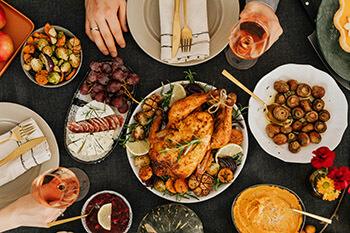 Thanksgiving spread with a turkey, roasted veggies, and wine