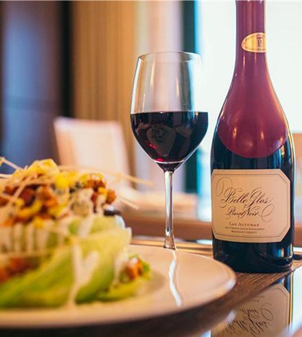 wine bottle and glass with dinner plate